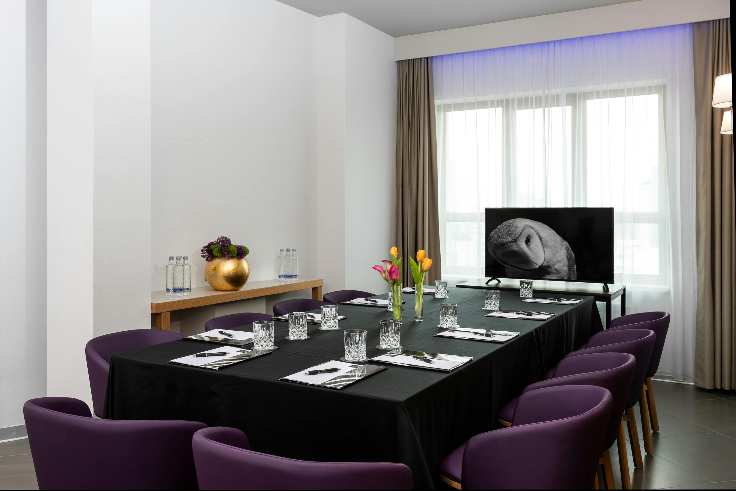 Sala meeting con sedie viola e tavolo nero
