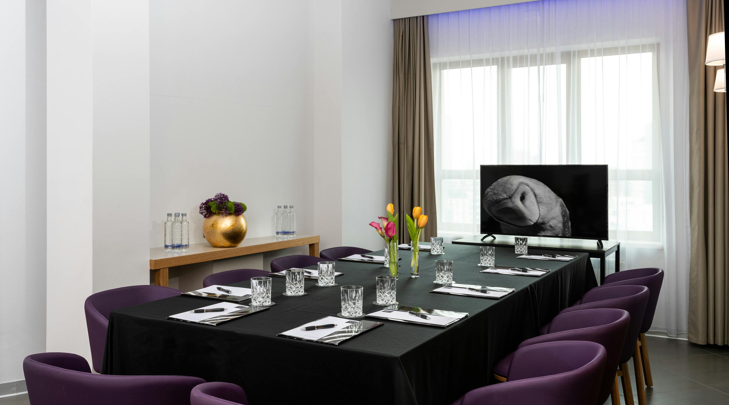 Meeting room with purple chairs and black table