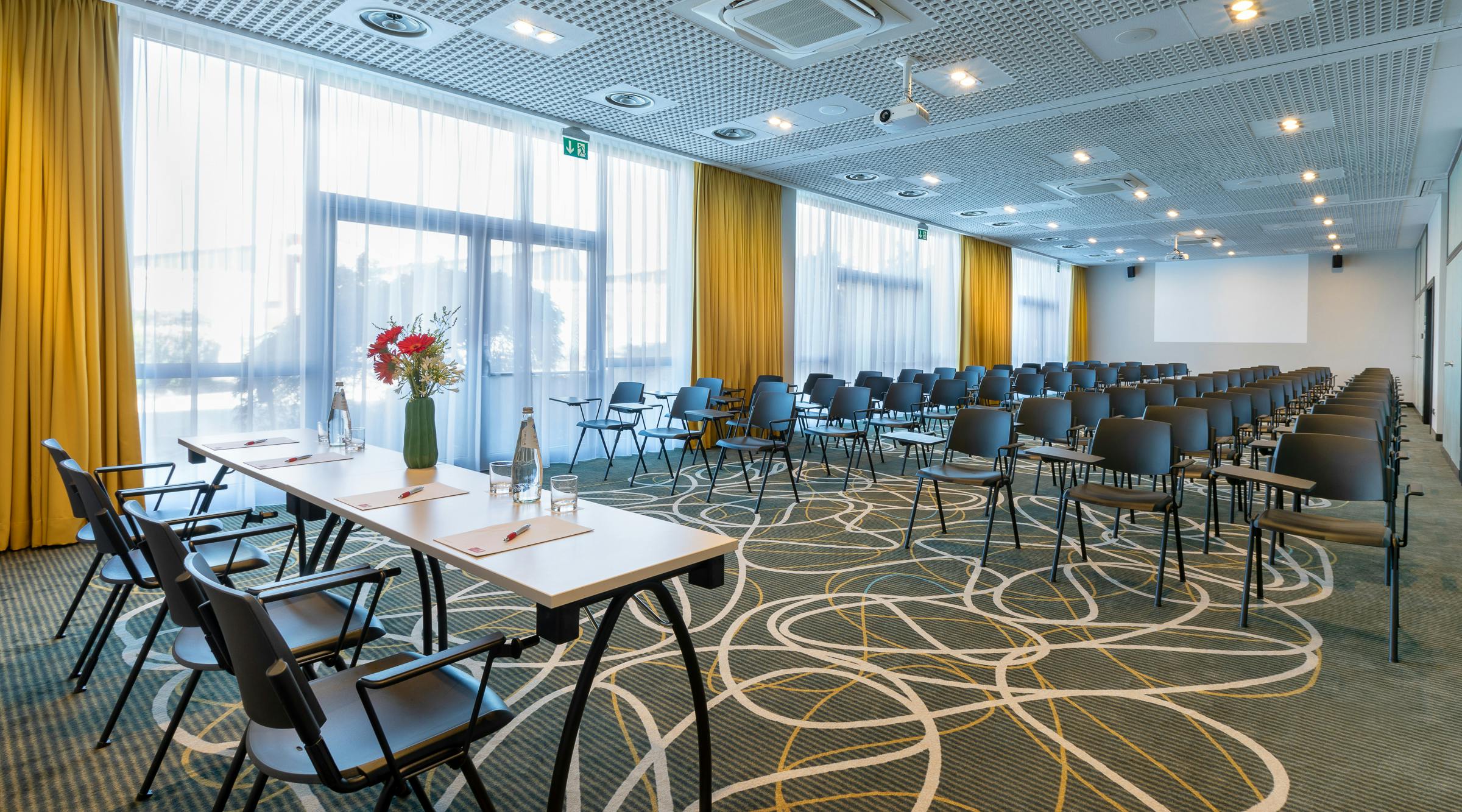 Meeting room with black chairs and table with flowers