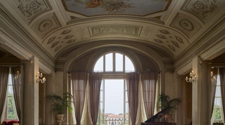 frescoed hall with a piano