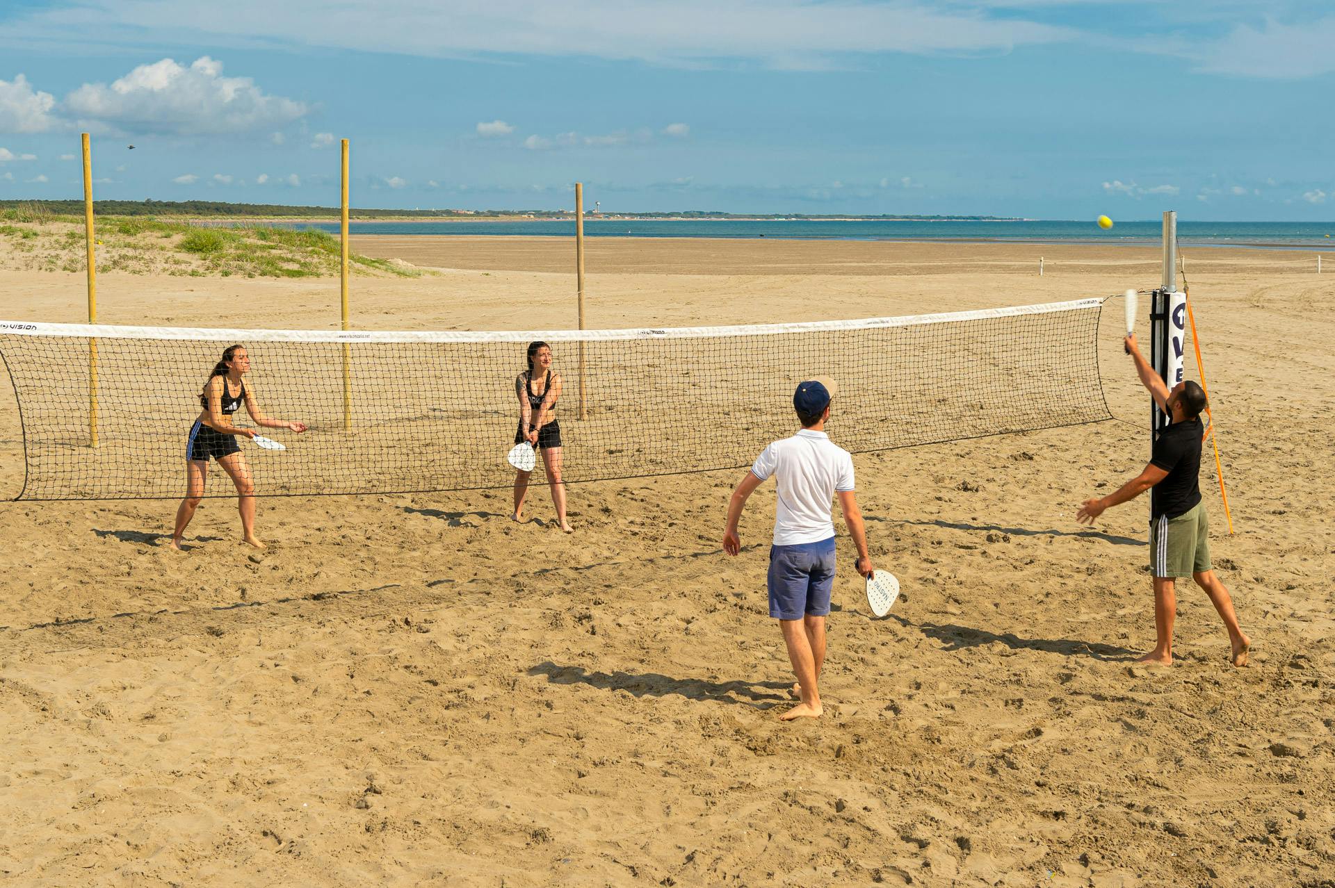 guys playing tennis at the beach