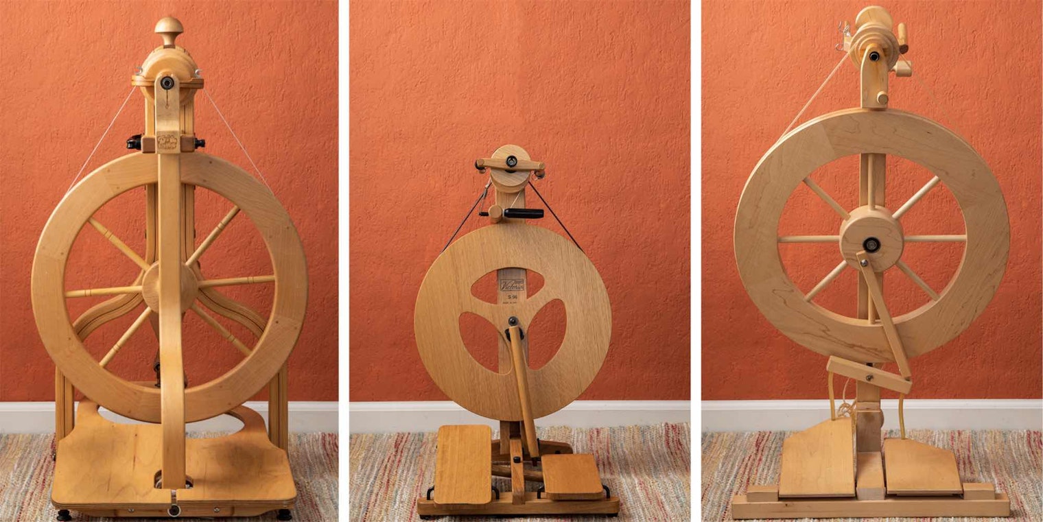 Three spinning wheels in front of an orange wall
