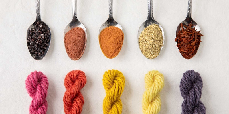 spoons holding natural dyestuffs and colored skeins of yarn
