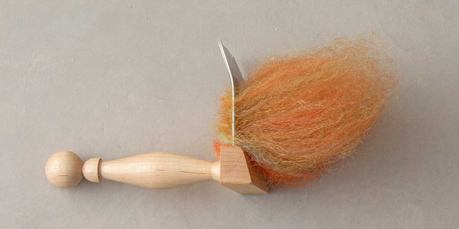 wool comb with orange fiber