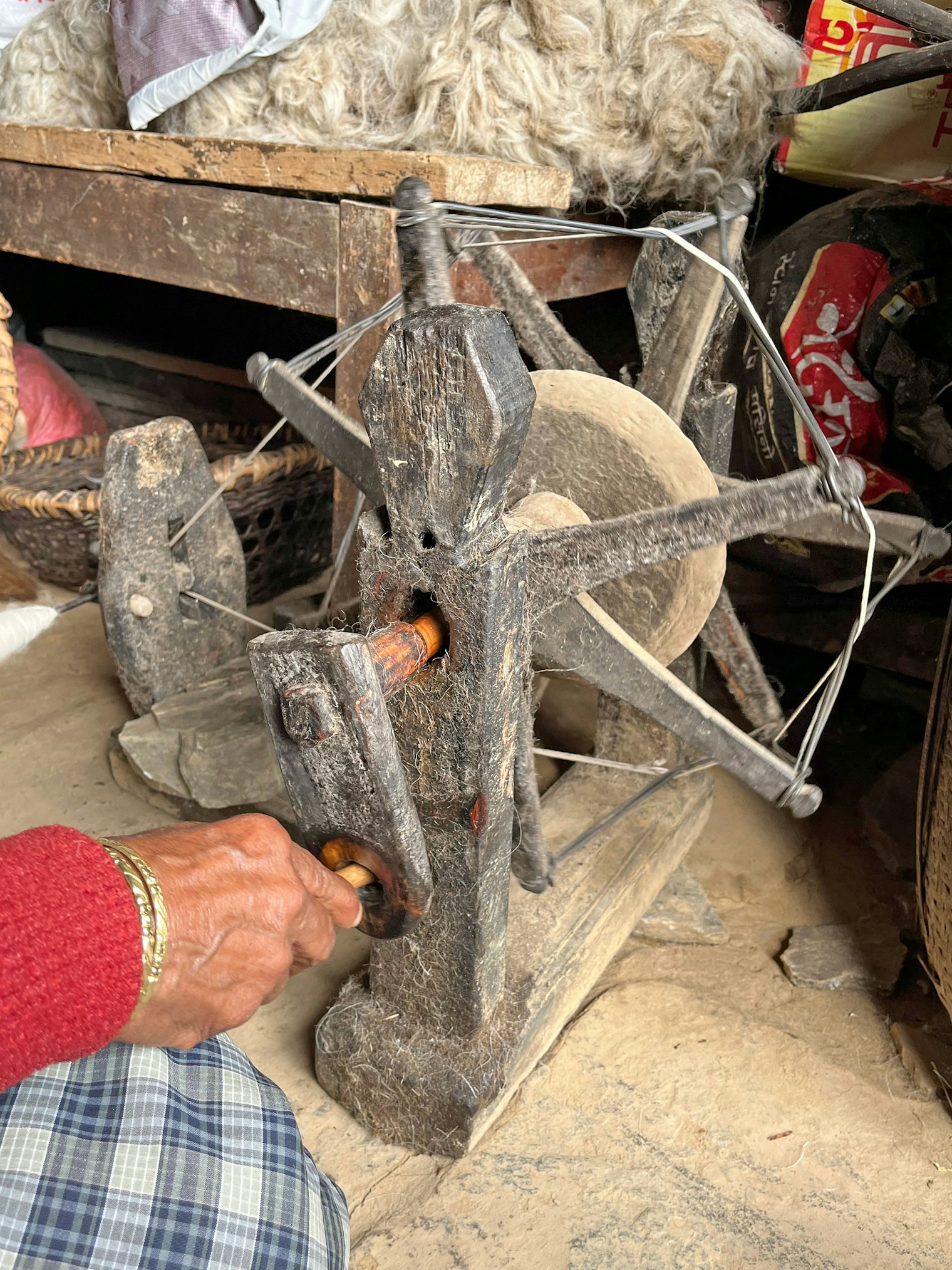 The dowel handle is used to spin the wheel on this charkha from the village of Ghandruk.