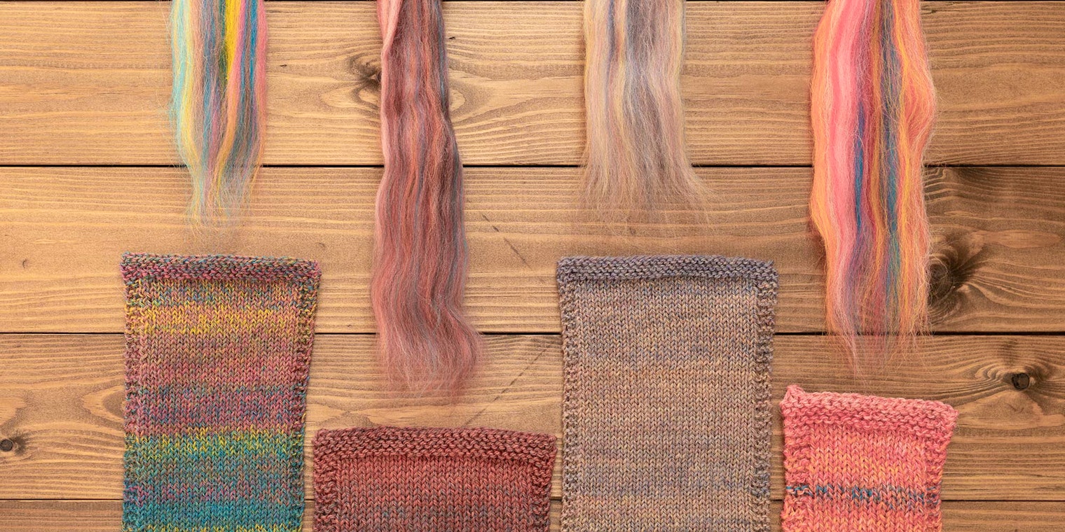 Swatches and fiber rest on a wood surface.