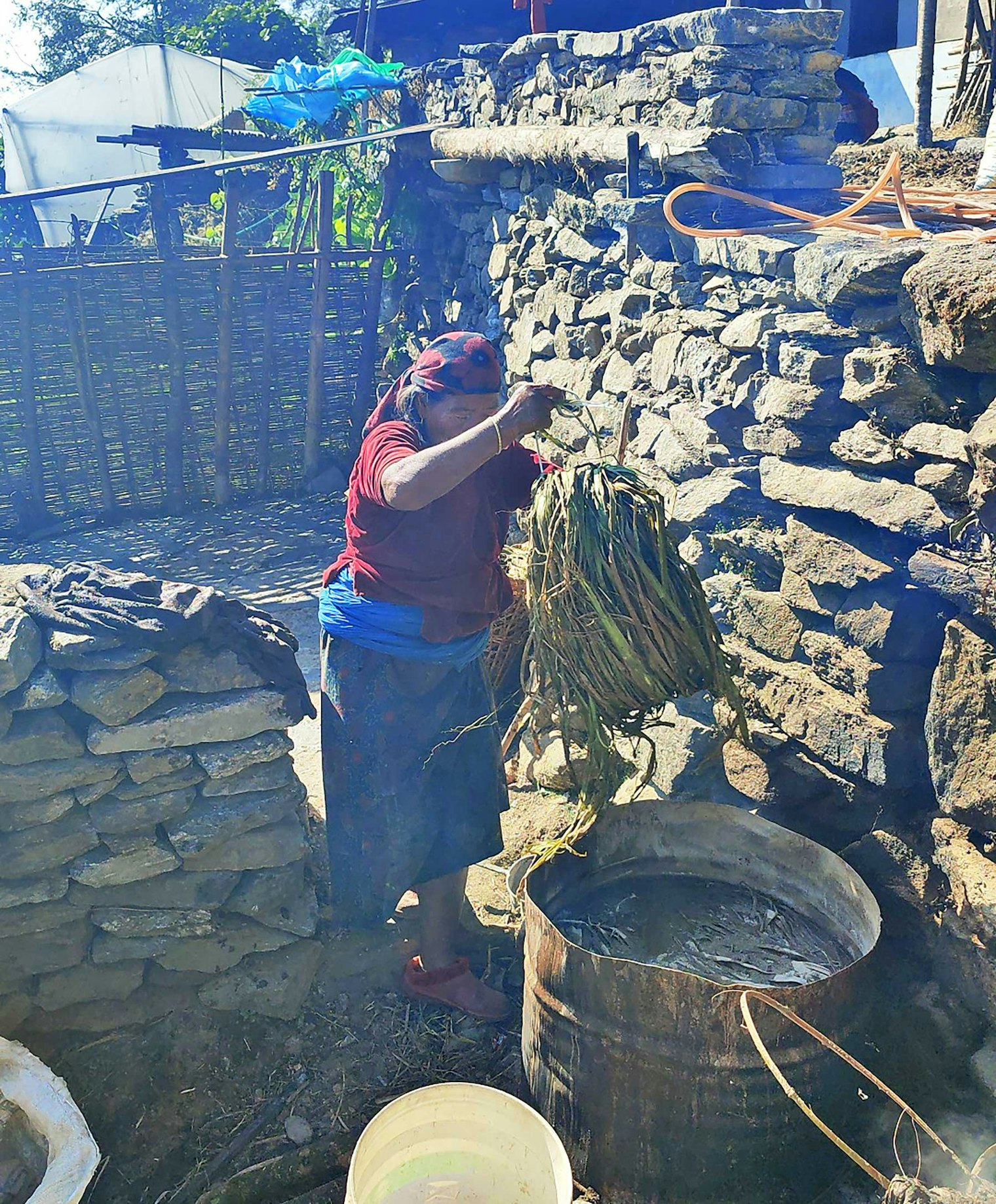 Kho Maya adds a bundle of allo to the barrel. Photo by Umesh Das