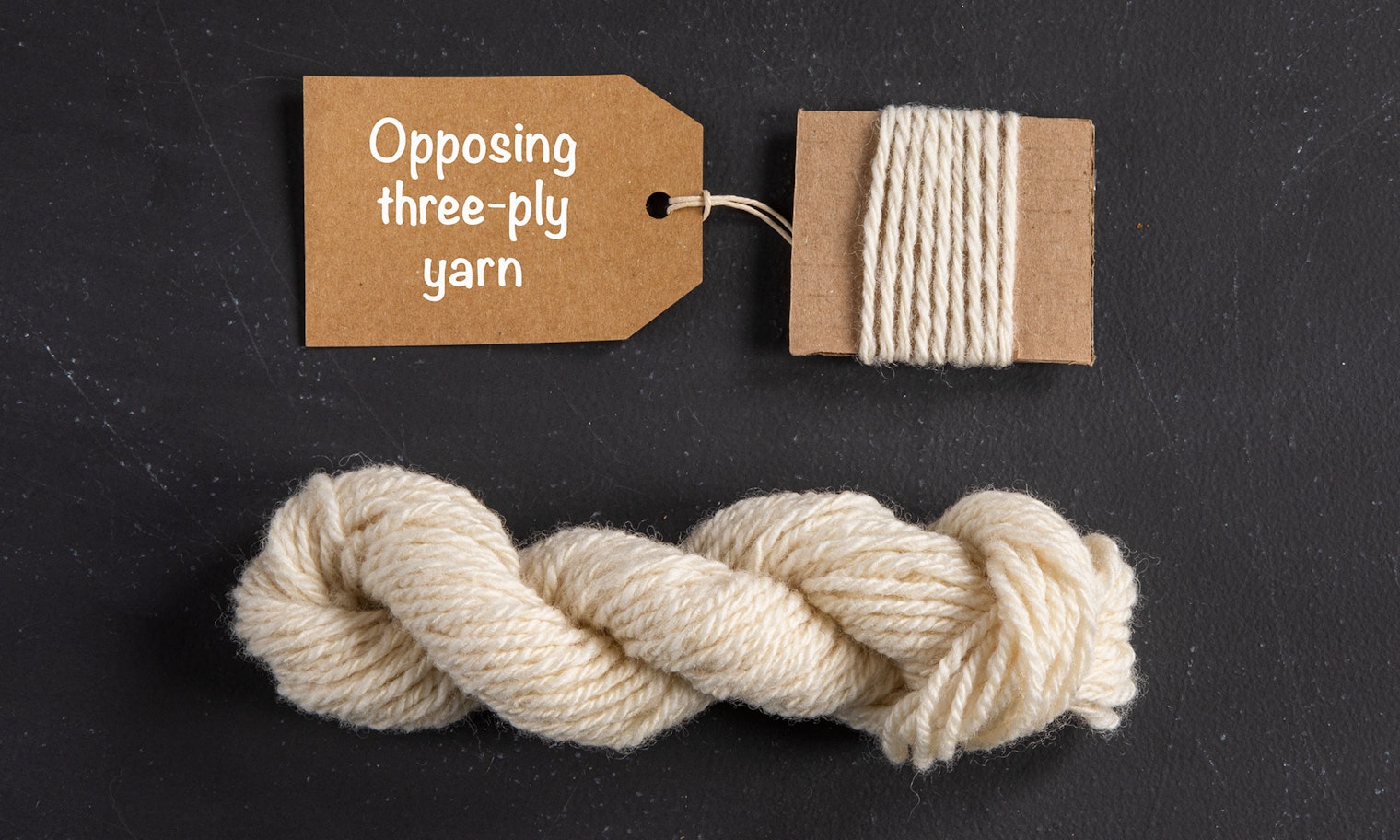 skein of offwhite yarn on black background