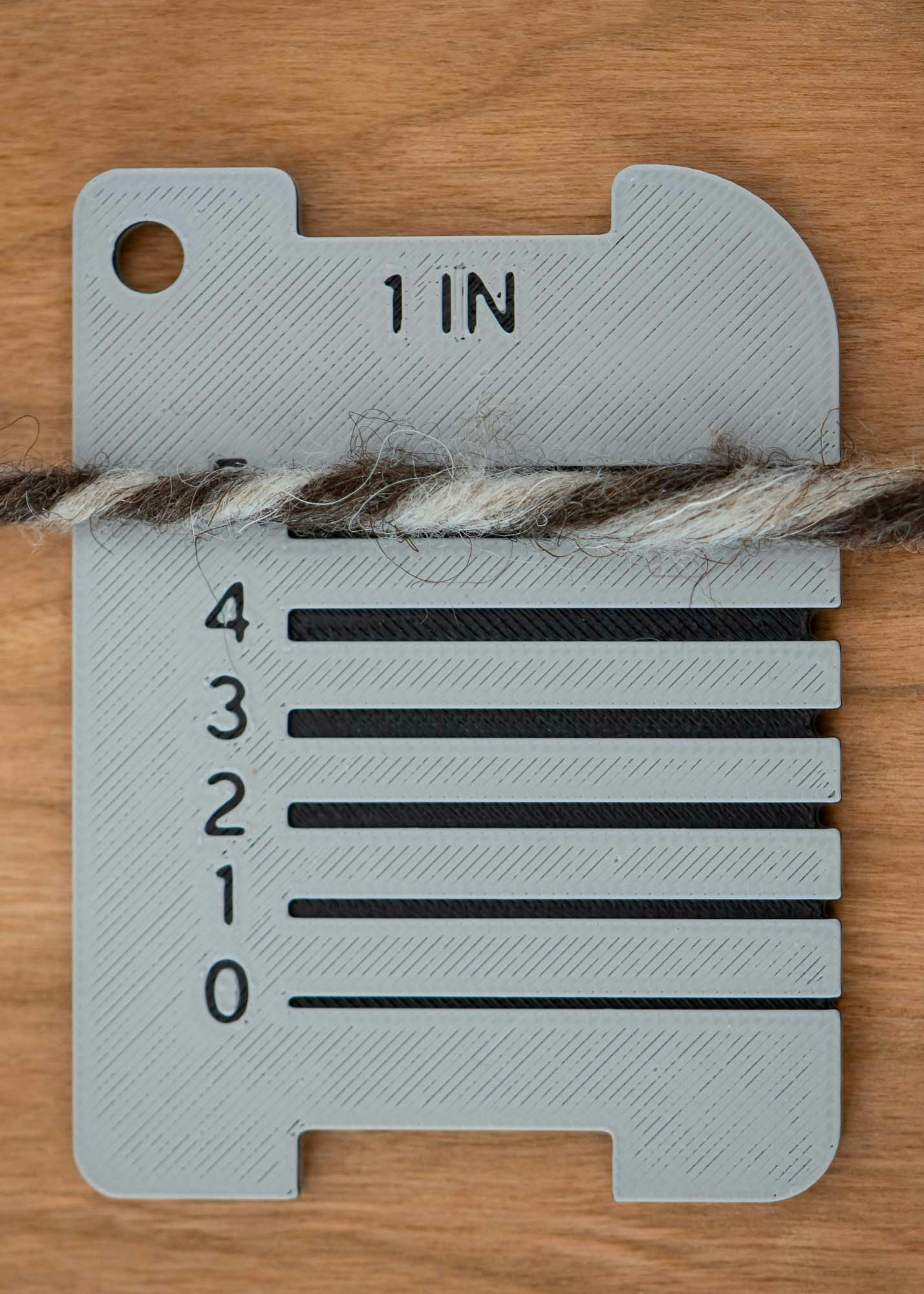 The numbers on this 3D-printed control card from LoftyFiber indicate Craft Yarn Council yarn weights.
