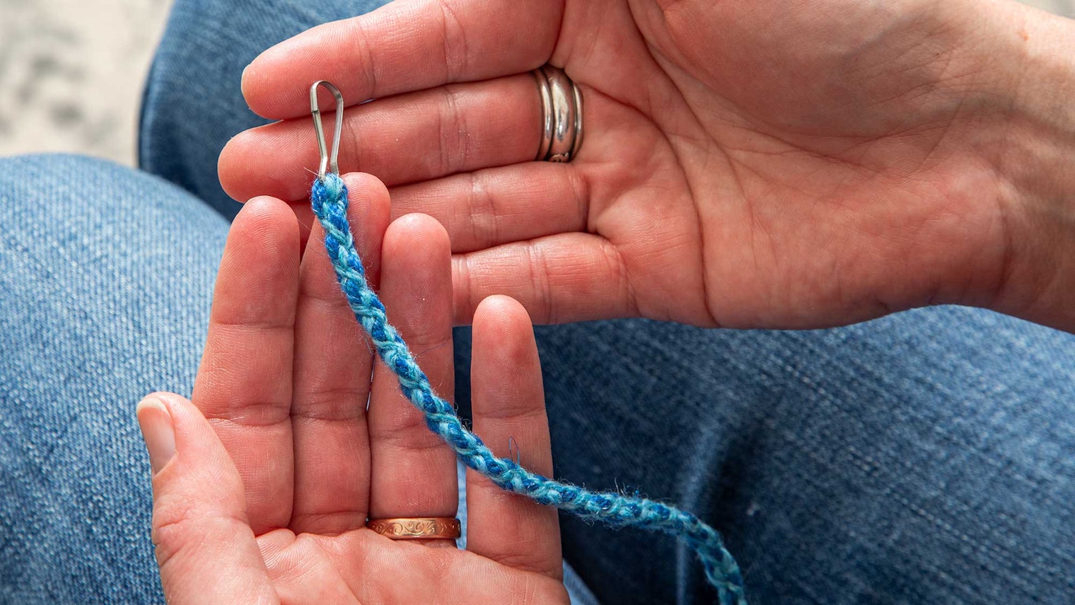 Hands holding a kumihimo braid