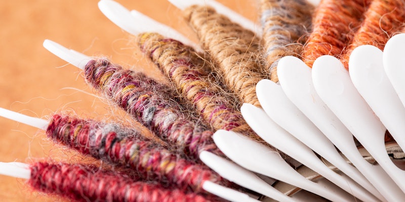 A closeup view of handspun yarn samples wound onto embroidery floss holders.