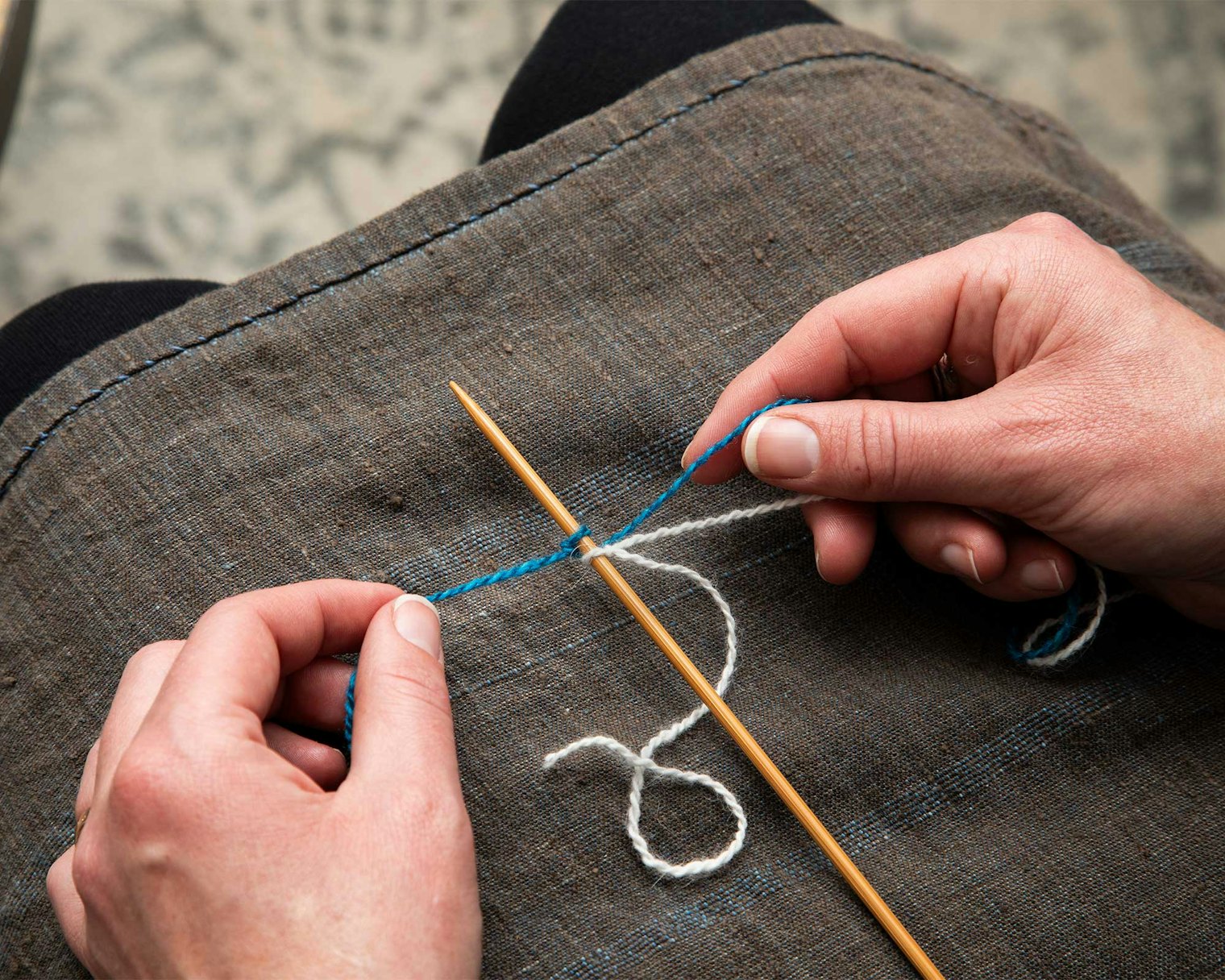 With MC tail in left hand and other 2 strands in right hand, pick up the tail to make a loop with the left thumb as for the long-tail cast-on.