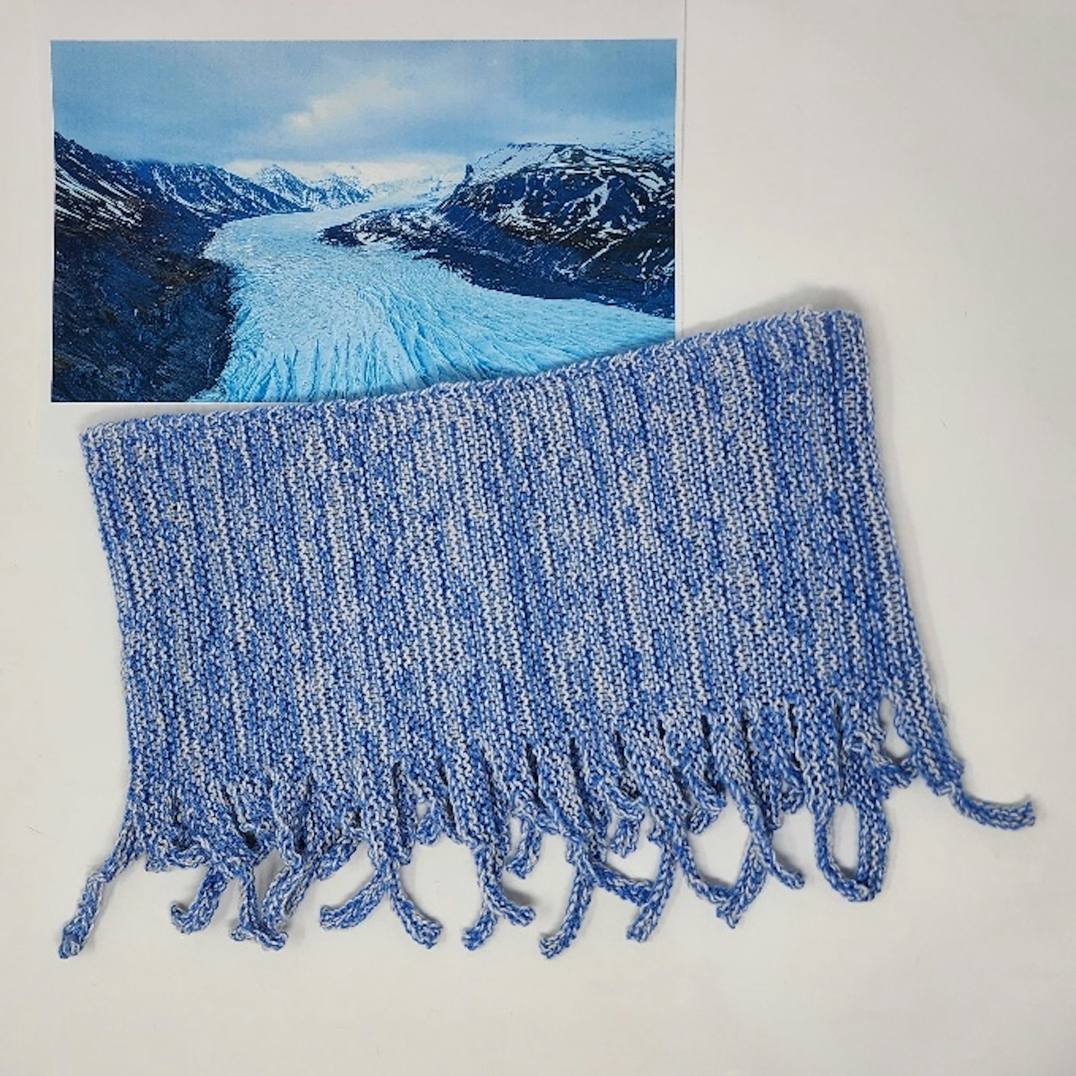 Flowing Glacier Cowl. Photo and submission from Gabi van Tassell. "Two colors of superbly soft cashmere simulate the color play of glacier crevices, and the knitted fringes reflect where the ice breaks up."