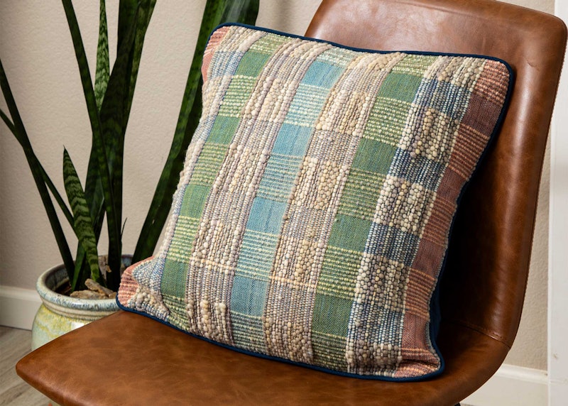 A textured pillow on a chair.