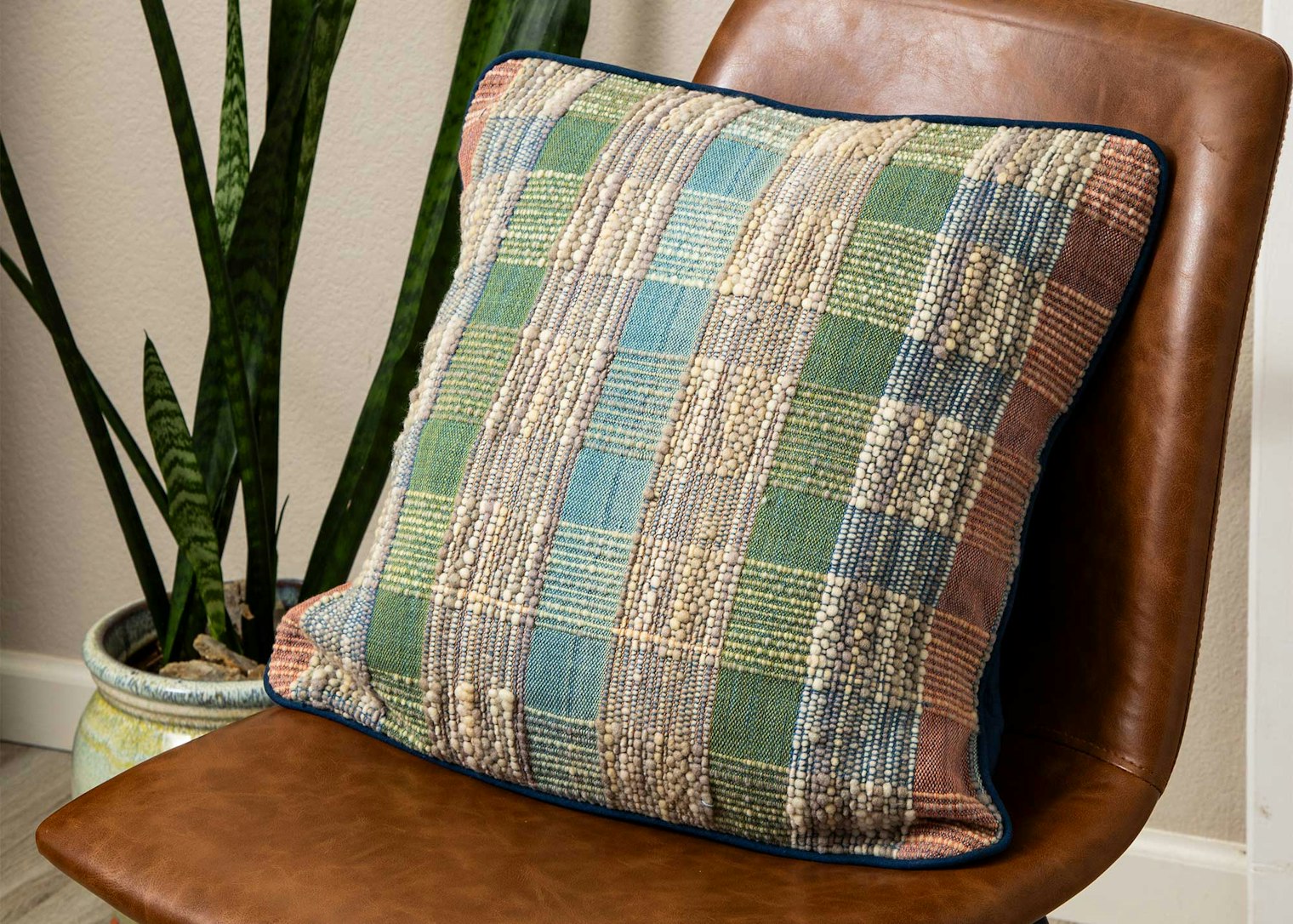 A textured pillow on a chair.