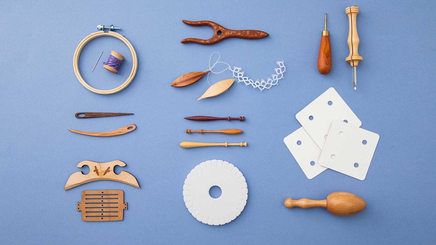 An assortment of fiber arts tools on a blue background.