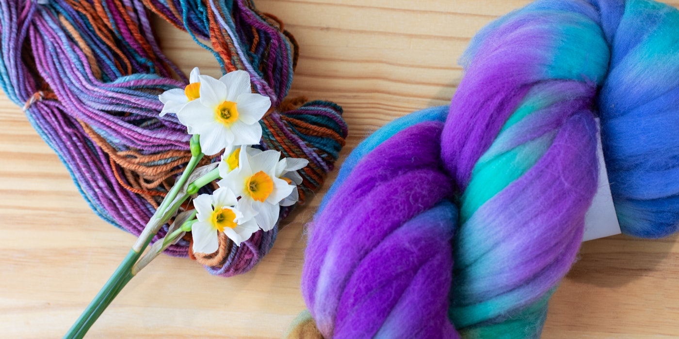 Spins from 5 Ways to Prep and Spin a Braid, daffodils, and a new way to package fiber, shown on a wooden background.