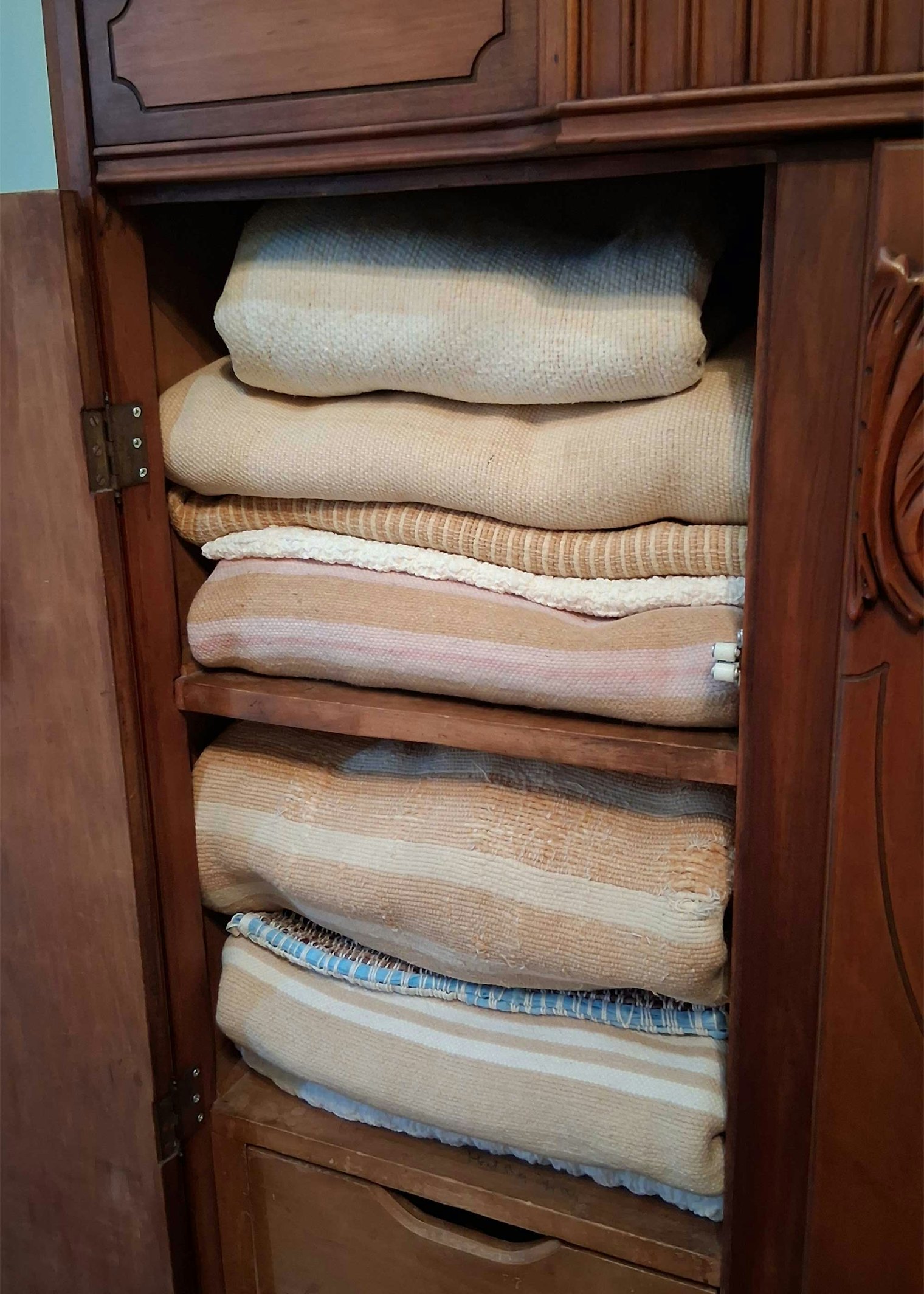 A stack of antique Acadian brown cotton blankets. Some are so old the color has faded.
