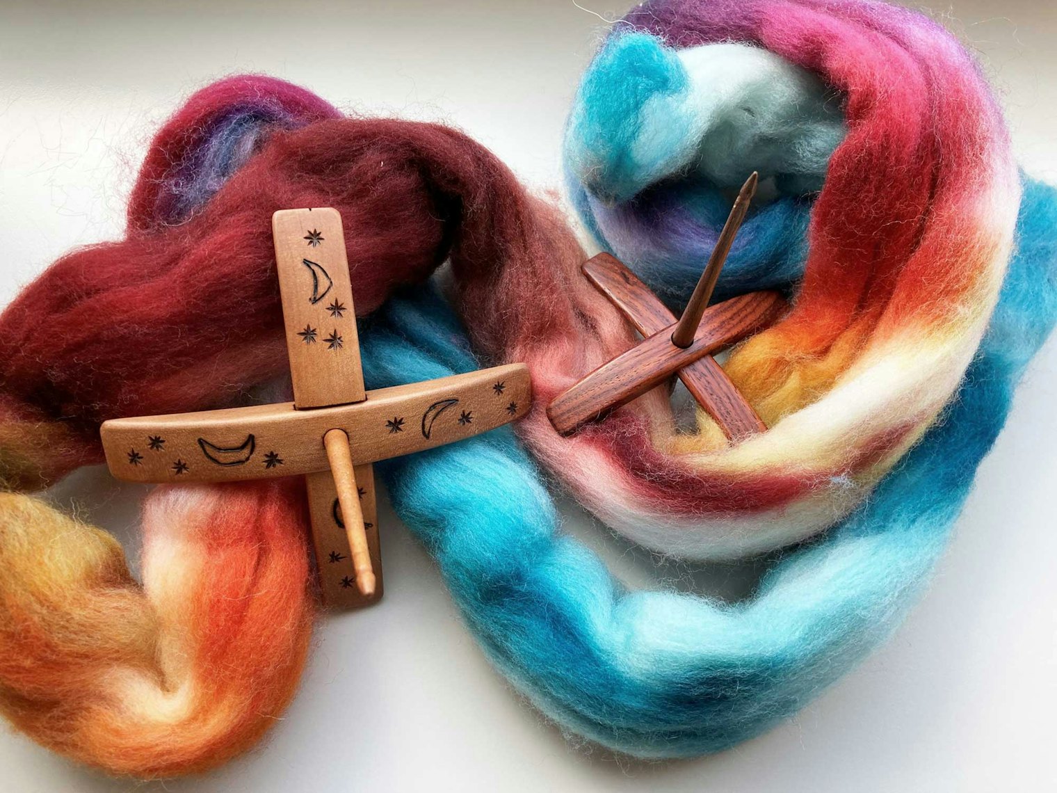 Two turkish spindles on colorful dyed fiber
