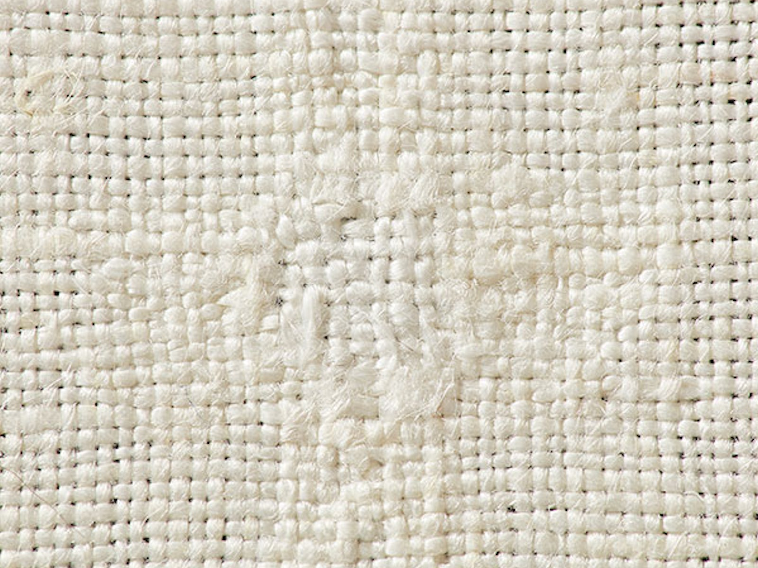 The invisible technique of linen darning is worked on the wrong side of the fabric by laying in a warp and weaving a plain-weave weft across. Photo by George Boe