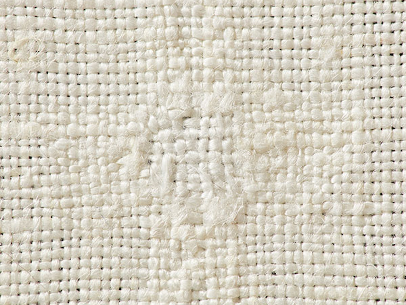 The invisible technique of linen darning is worked on the wrong side of the fabric by laying in a warp and weaving a plain-weave weft across. Photo by George Boe