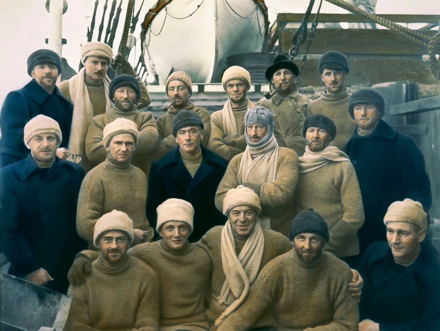 *Hand-tinted photograph of members of the British, Australian, and New Zealand Antarctic Research Expedition (BANZARE) of 1929–1931. Sir Douglas Mawson, the only one wearing a balaclava, is in the second row, third from right.*