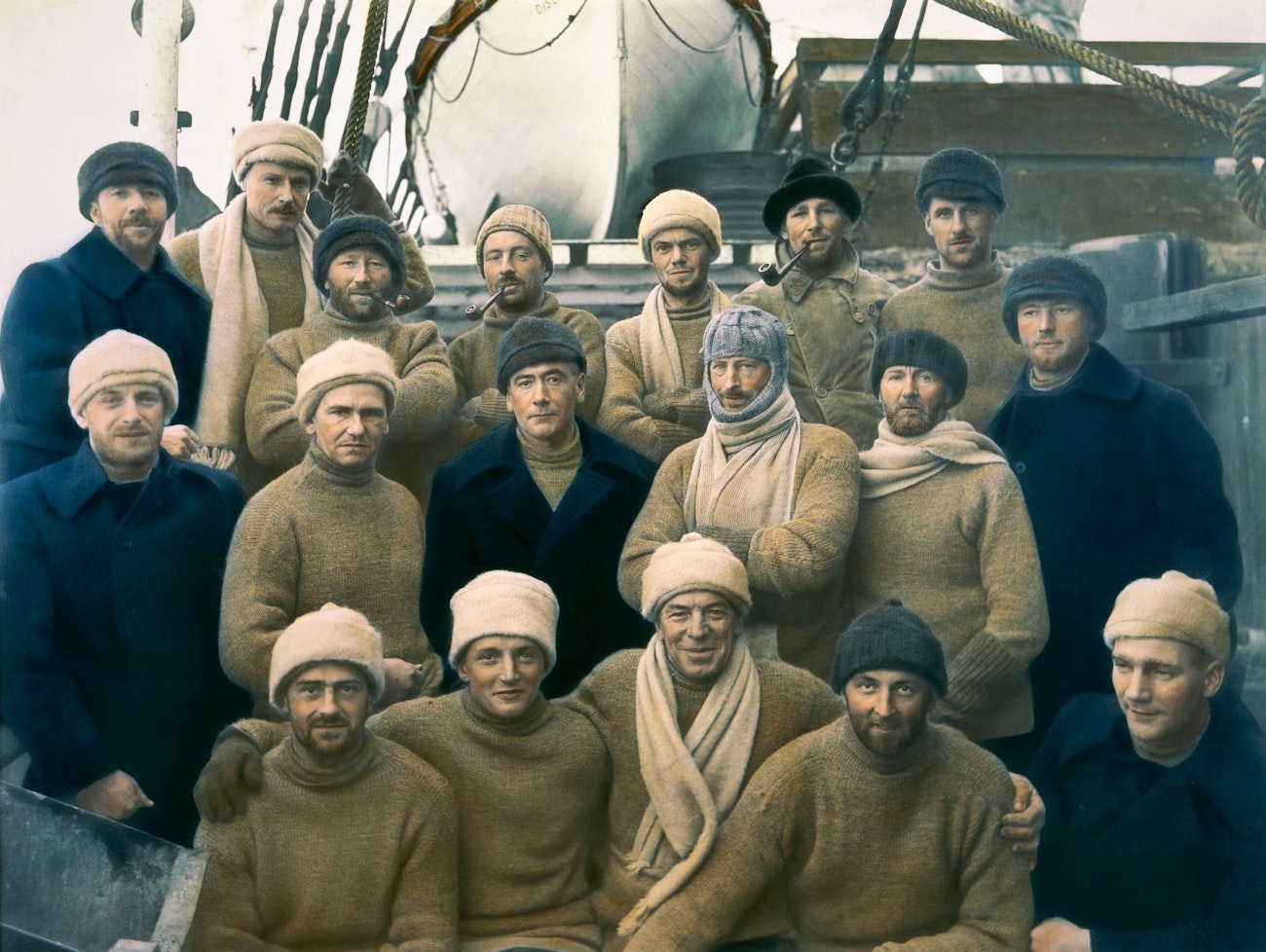 <em>Hand-tinted photograph of members of the British, Australian, and New Zealand Antarctic Research Expedition (BANZARE) of 1929–1931. Sir Douglas Mawson, the only one wearing a balaclava, is in the second row, third from right.</em>