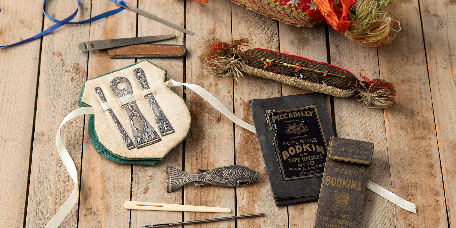 A collection of antique bodkins and various commercial and handmade bodkin holders, as seen in PieceWork Summer 2022. Photo by Matt Graves