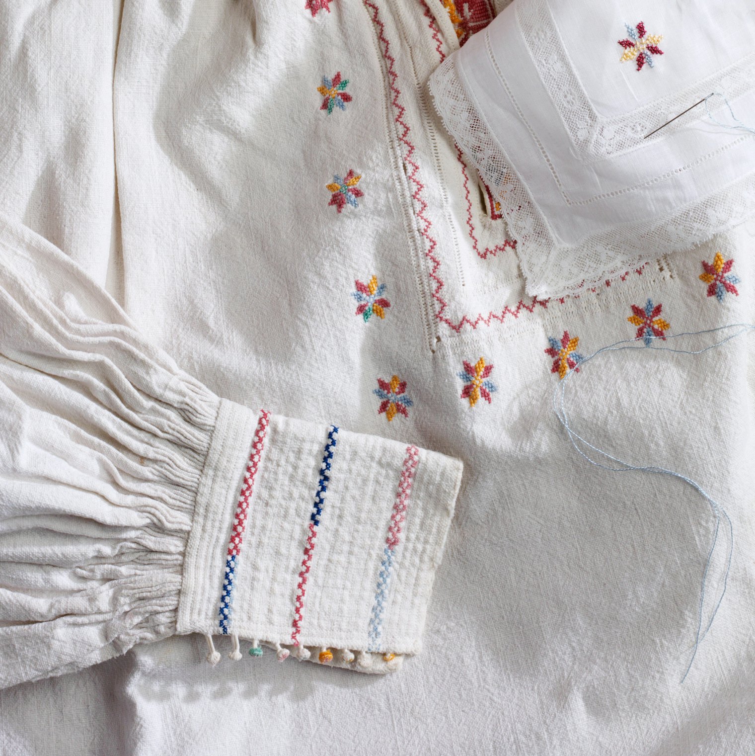 The delicate cross-stitch embroidery, needle-lace work around the neck opening, and tiny handworked multicolored covered buttons on this rarely worn example exhibit an exquisite attention to detail by its anonymous maker. Folkwear’s pattern #204 Missouri River Boatman’s Shirt was modeled after this original.