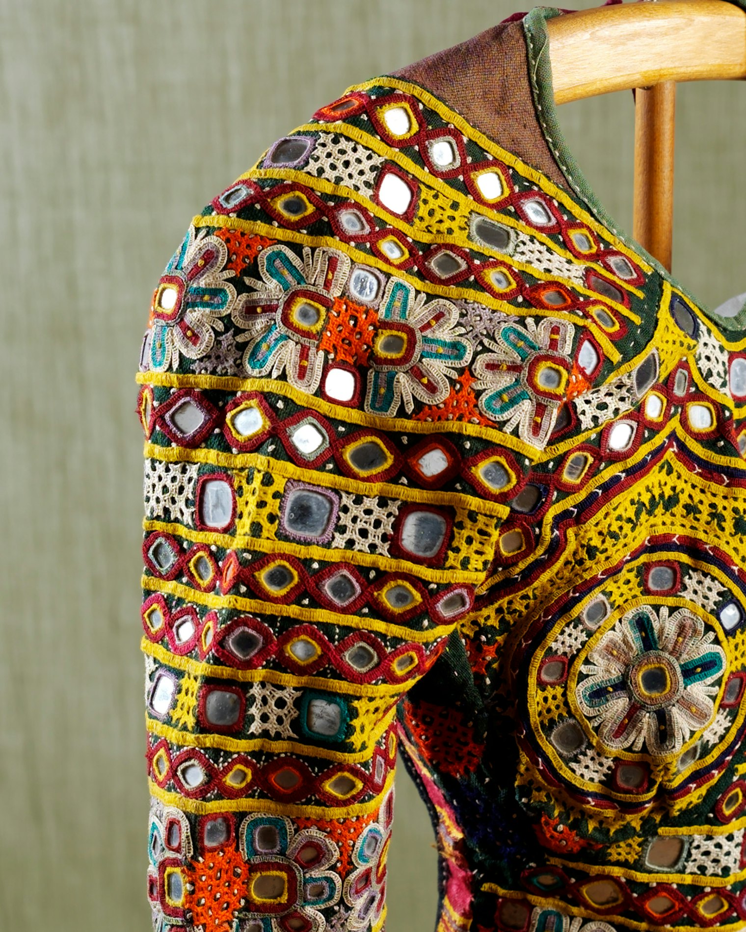 This example, with its modest midriff-covering panel, may reflect the Muslim influence of nearby Pakistan; elsewhere in India, the bodice would be shorter and more bralike. Its plain-woven cotton fabric is heavily embellished with shisha mirrors, open chain-stitch embroidery, and lacy woven threadwork. Garments like this one are often part of a dowry, made by women in the bride’s family, that includes clothing for both bride and groom, jewelry, and household goods.