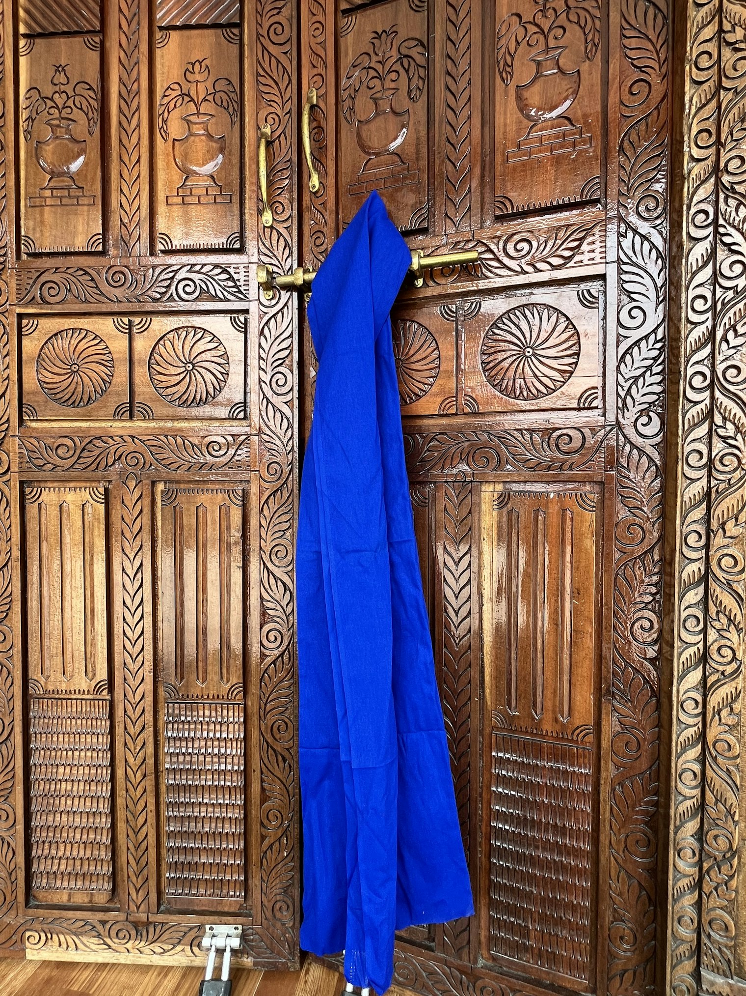 The blue patuki draped over the doorway reveals its tremendous length. The patuki holds practical value as a waist belt and also cultural value as a symbol of strength.