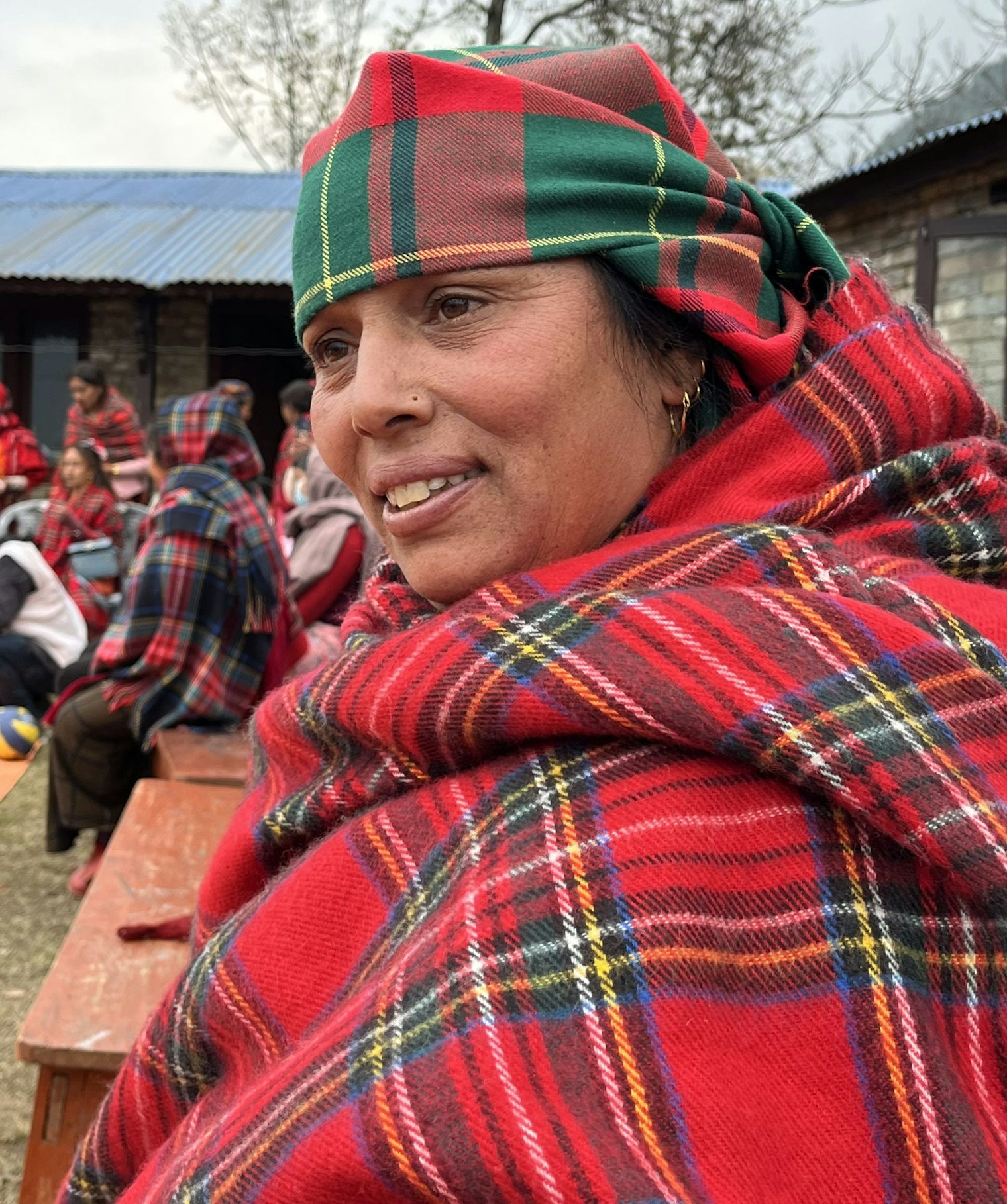 Hita wraps herself in multiple tartan pachauris at an outdoor festival.
