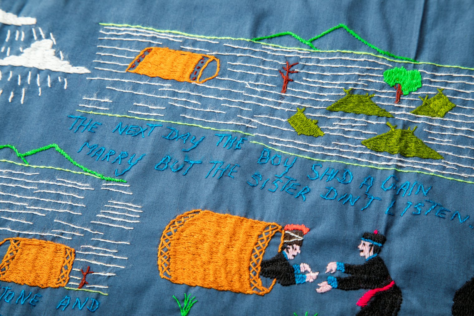 A scene depicting a traditional Hmong creation story in which a brother and sister survive a flood by floating in a large drum. Embroiderers usually outlined figures on cotton fabric and used a variety of stitches,notably long satin stitches to fill them in.