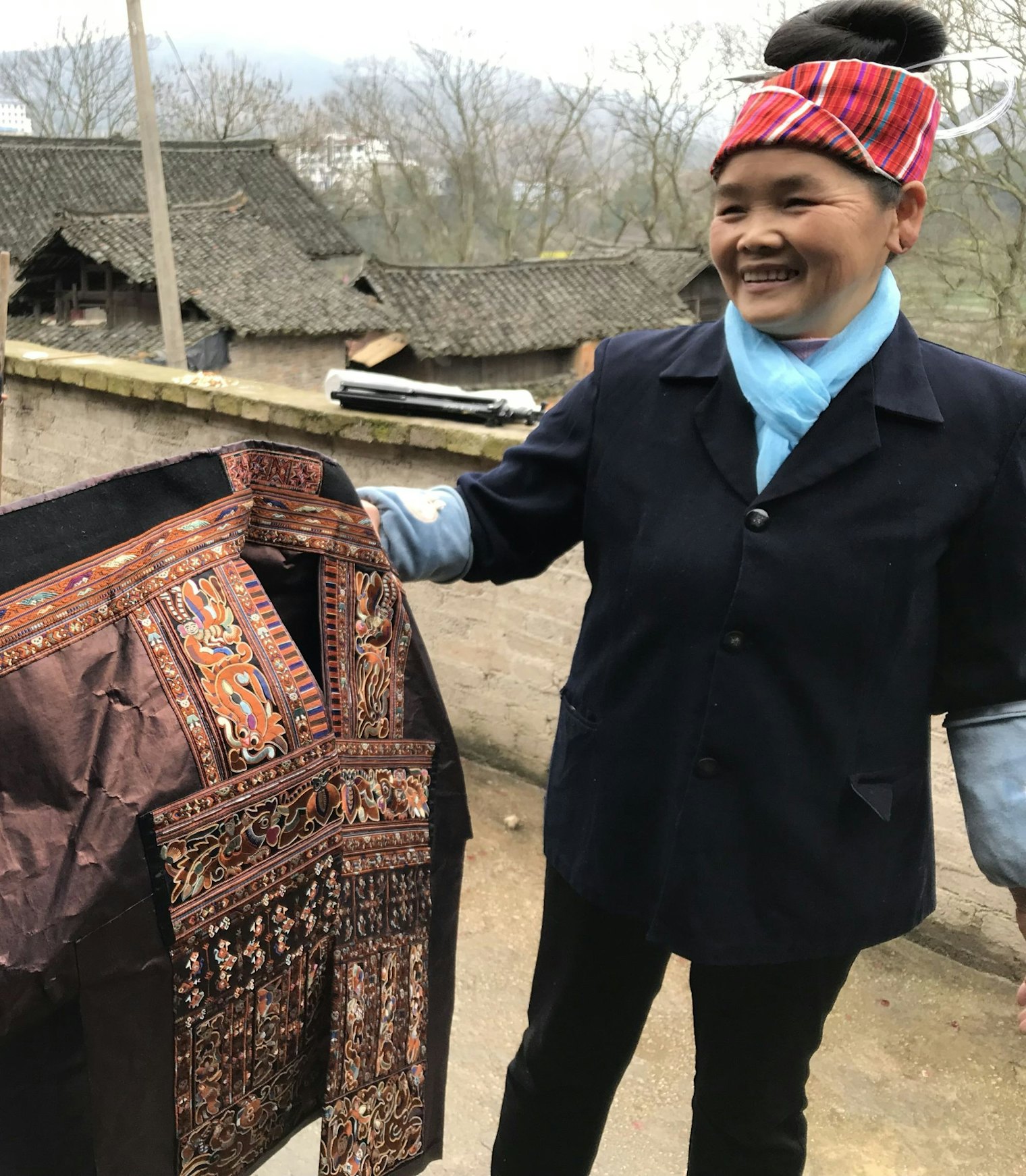 Tai Lao Xing displays a tour de force split-braid embroidery jacket in her village in Guizhou province, China.