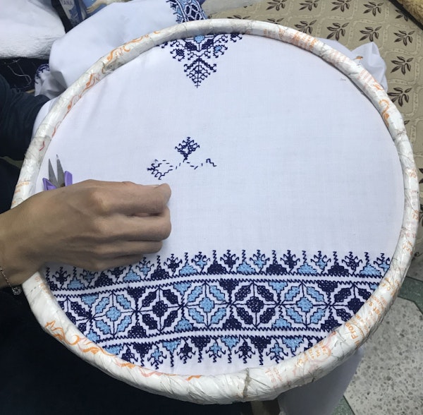 An embroidery artist stitches traditional fessi embroidery at a shop in the old medina in Fes, Morocco.