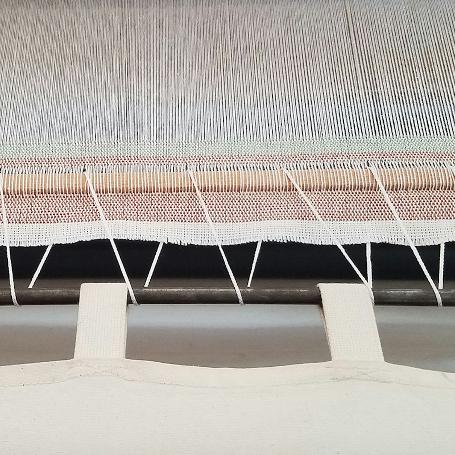 To cut off pieces before a warp her warp was done, Susan wove in a stick and lashed it to the cloth apron.