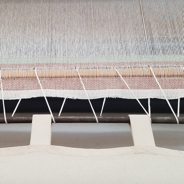 To cut off pieces before a warp her warp was done, Susan wove in a stick and lashed it to the cloth apron.