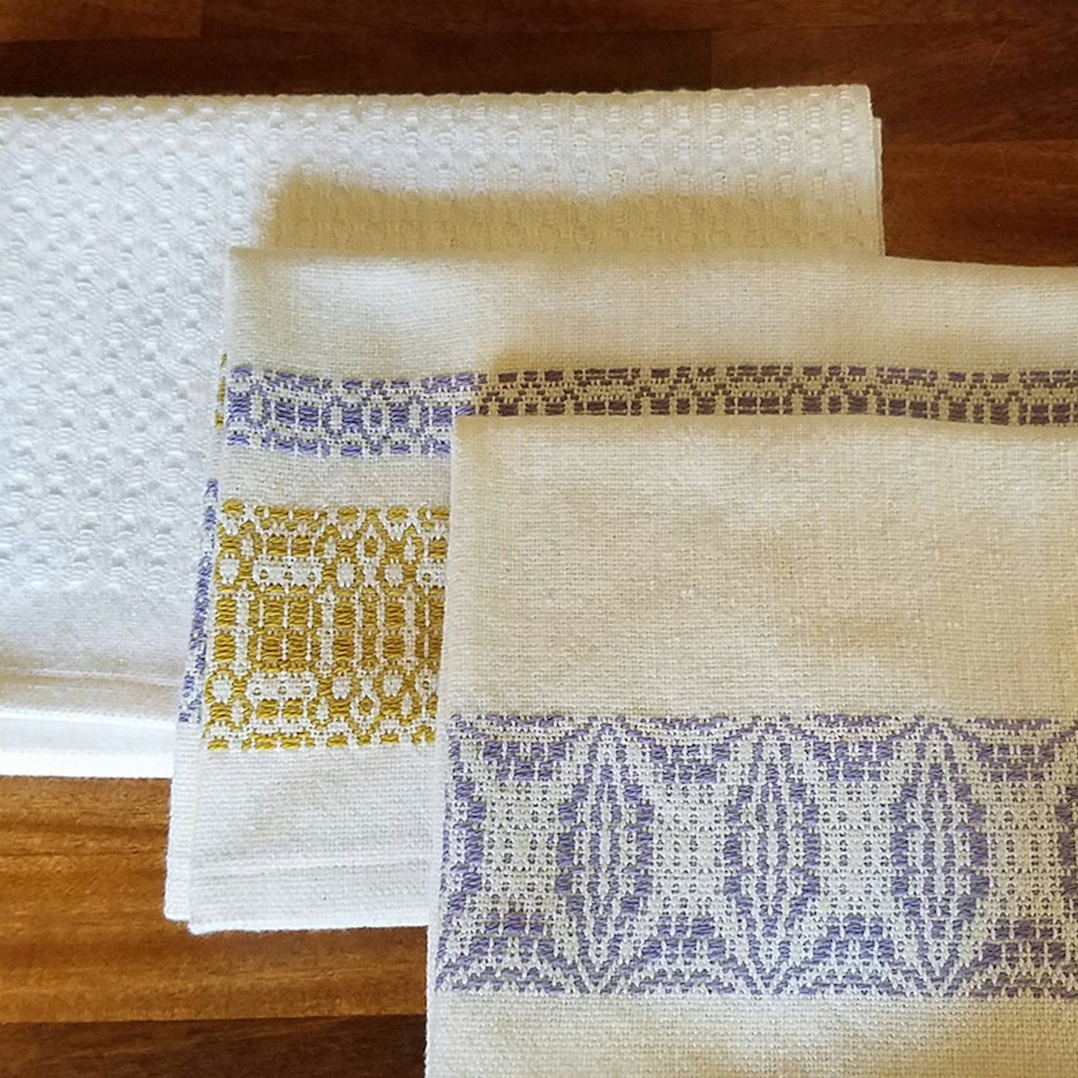 Shown from back: Huck ovals, Sweet and Lovely overshot bands, and Orange Peel overshot bands were the first towels from the warp.