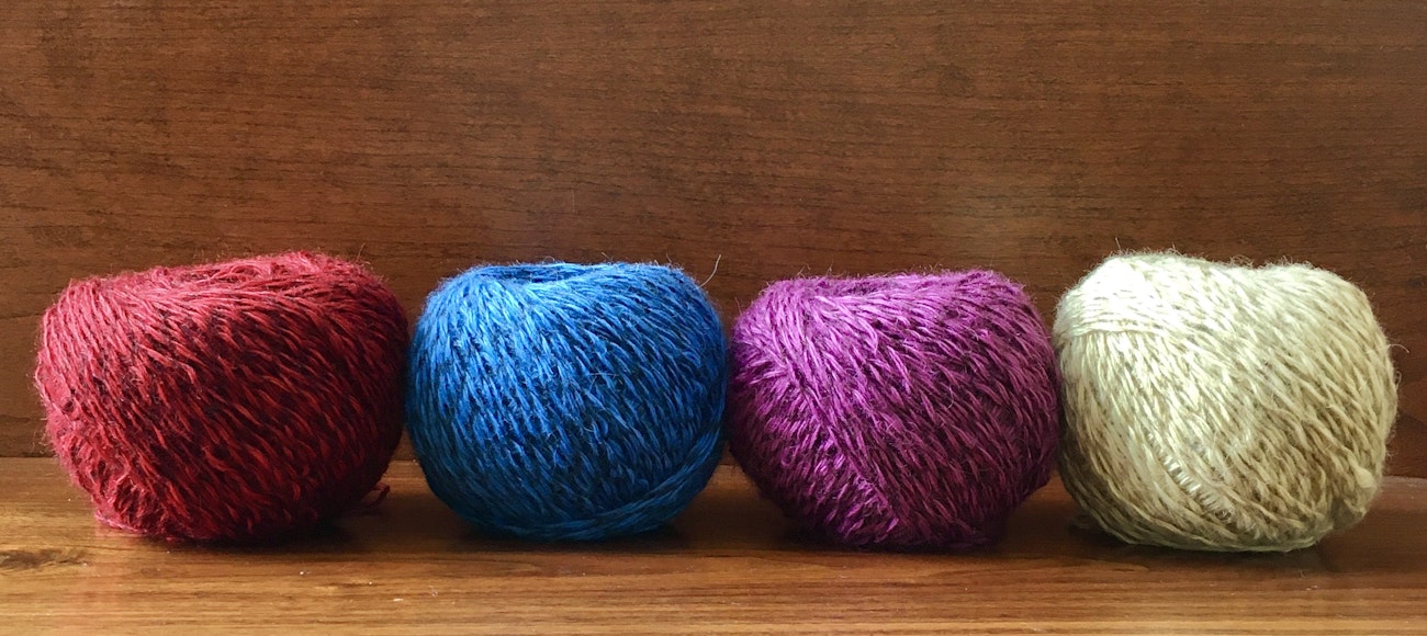 Four balls of yarn (red, blue, magenta, yellow)