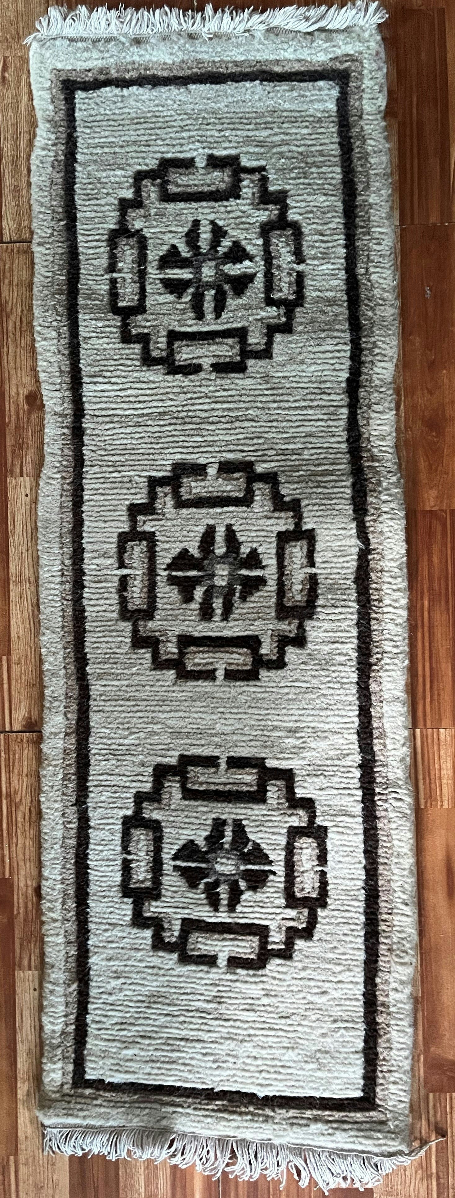 This seating pad galaicha is about 25 years old. The design is less ornate, and the floral frame has become a simple plain border. From the collection of Tara Paudel