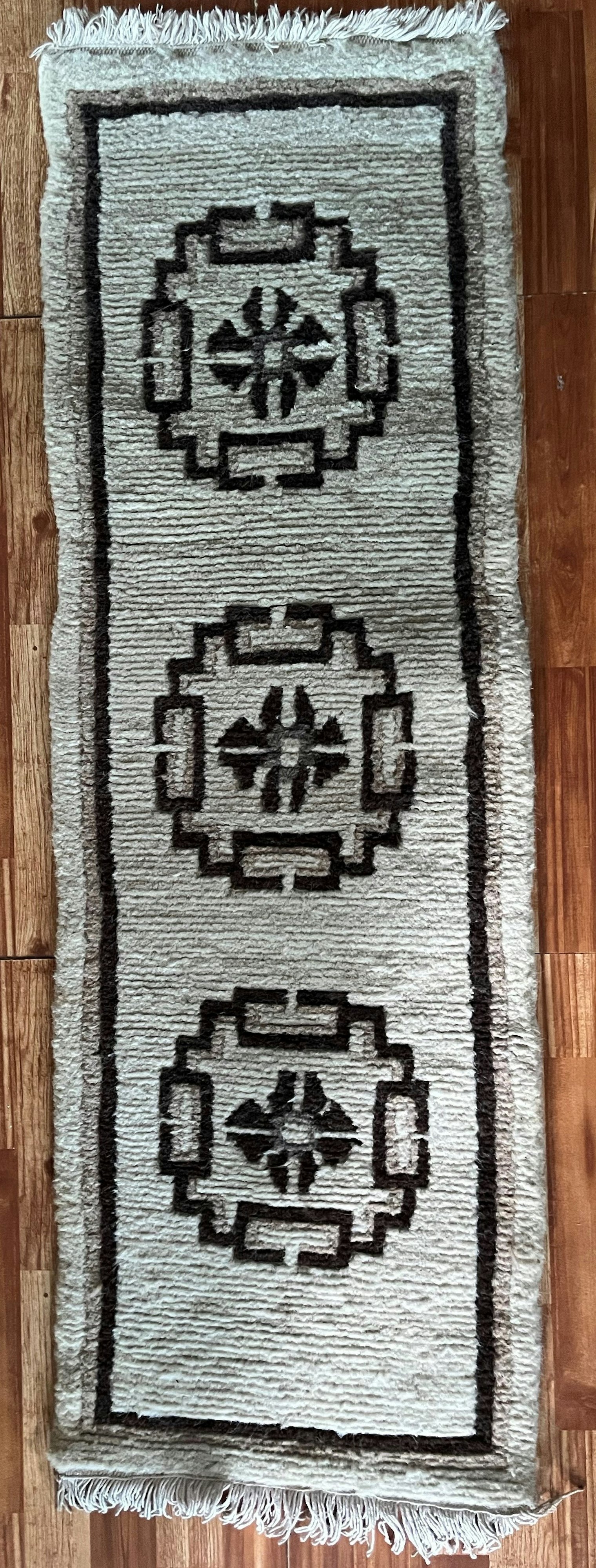 This seating pad galaicha is about 25 years old. The design is less ornate, and the floral frame has become a simple plain border. From the collection of Tara Paudel