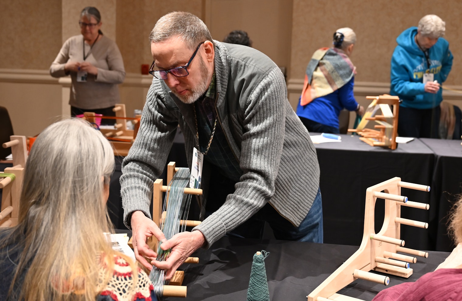 John Mullarkey, facing camera, provides a helping hand in one of his card-weaving classes.