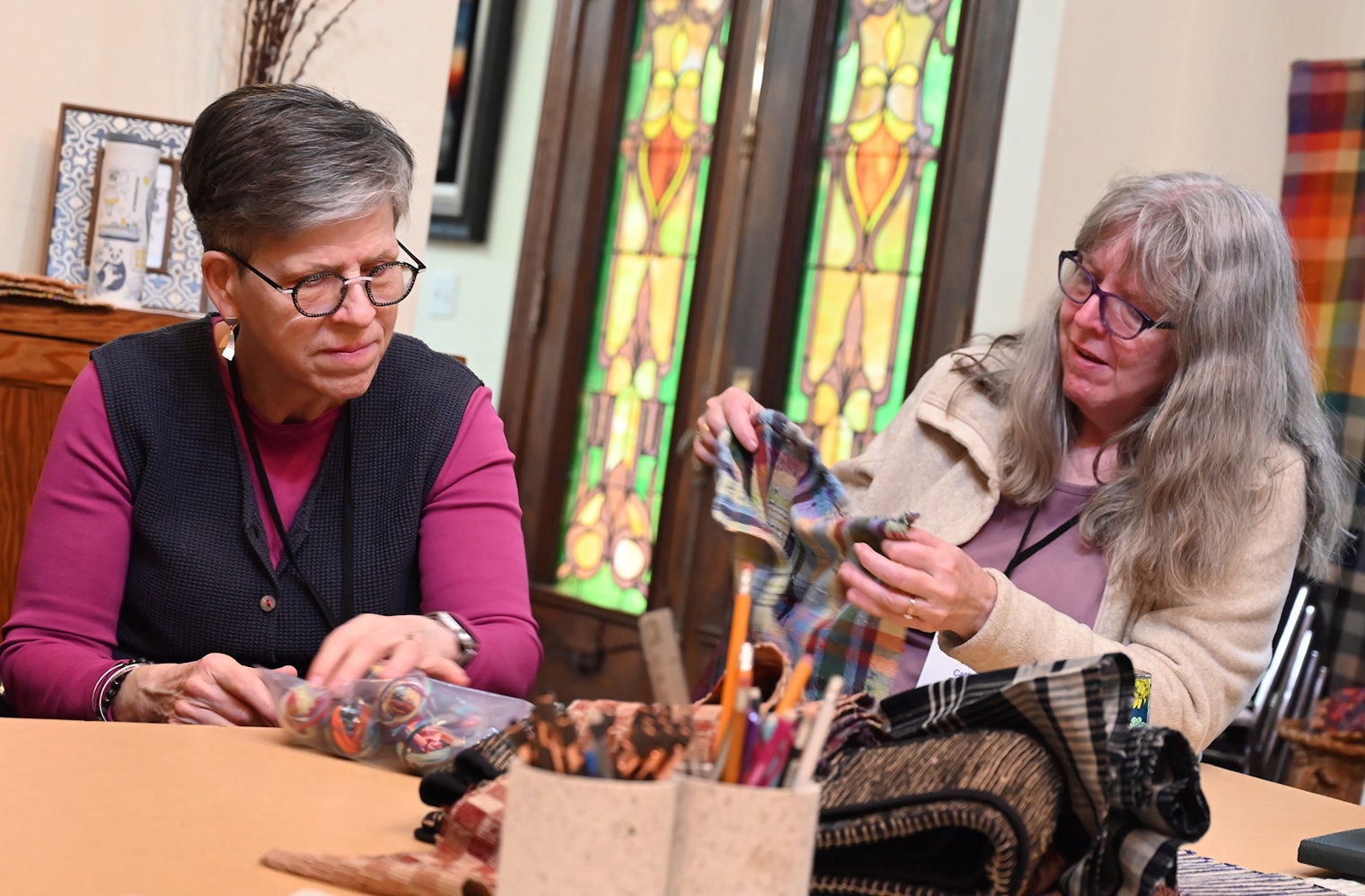 Students in Tom Knisely‘s “Sakiori and Zanshi” class take a closer look at woven samples at Weave Together 2025.