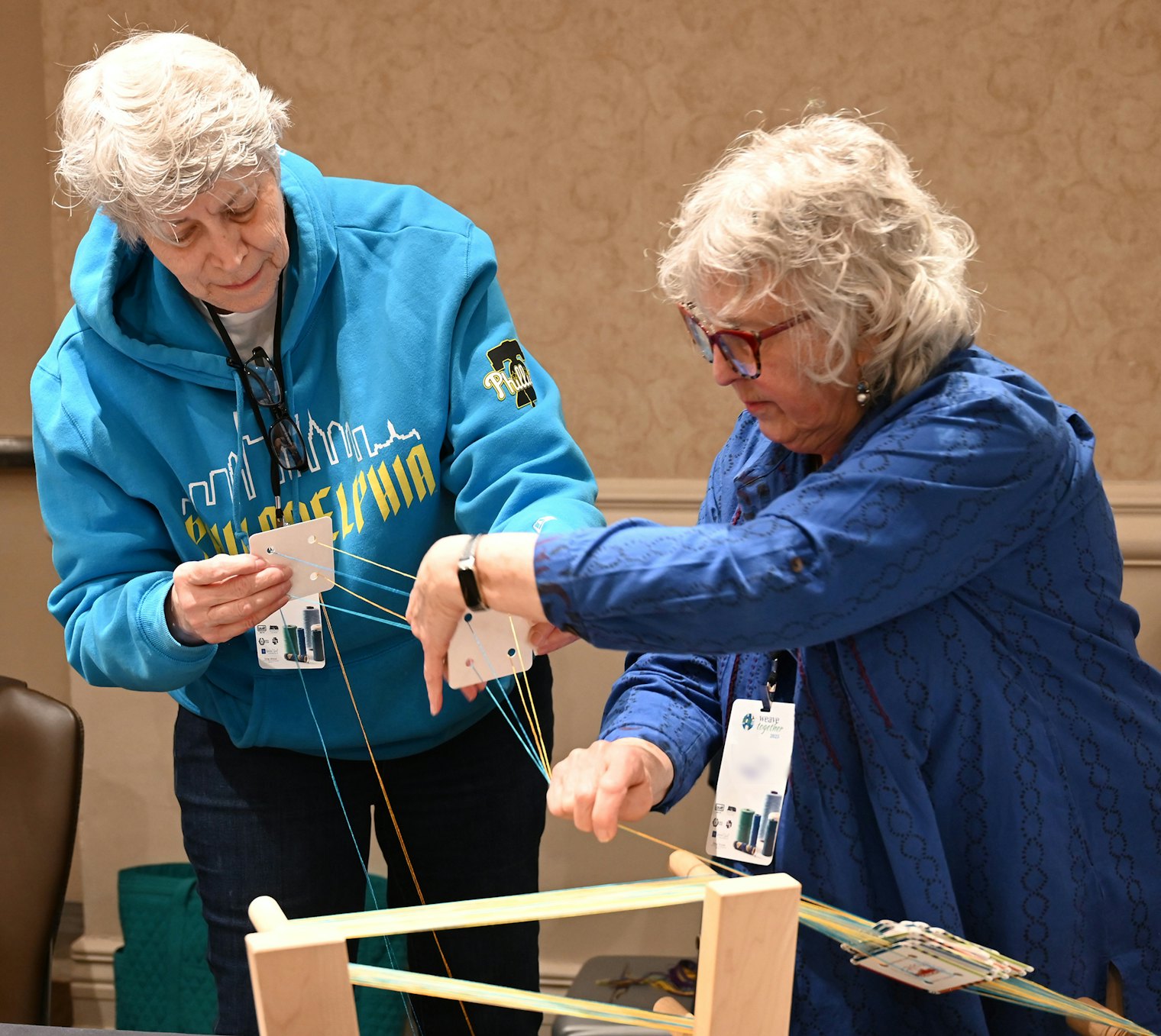 Weavers pair up to thread cards for John Mullarkey’s “Double-Card Double-Turn Diagonals” class.