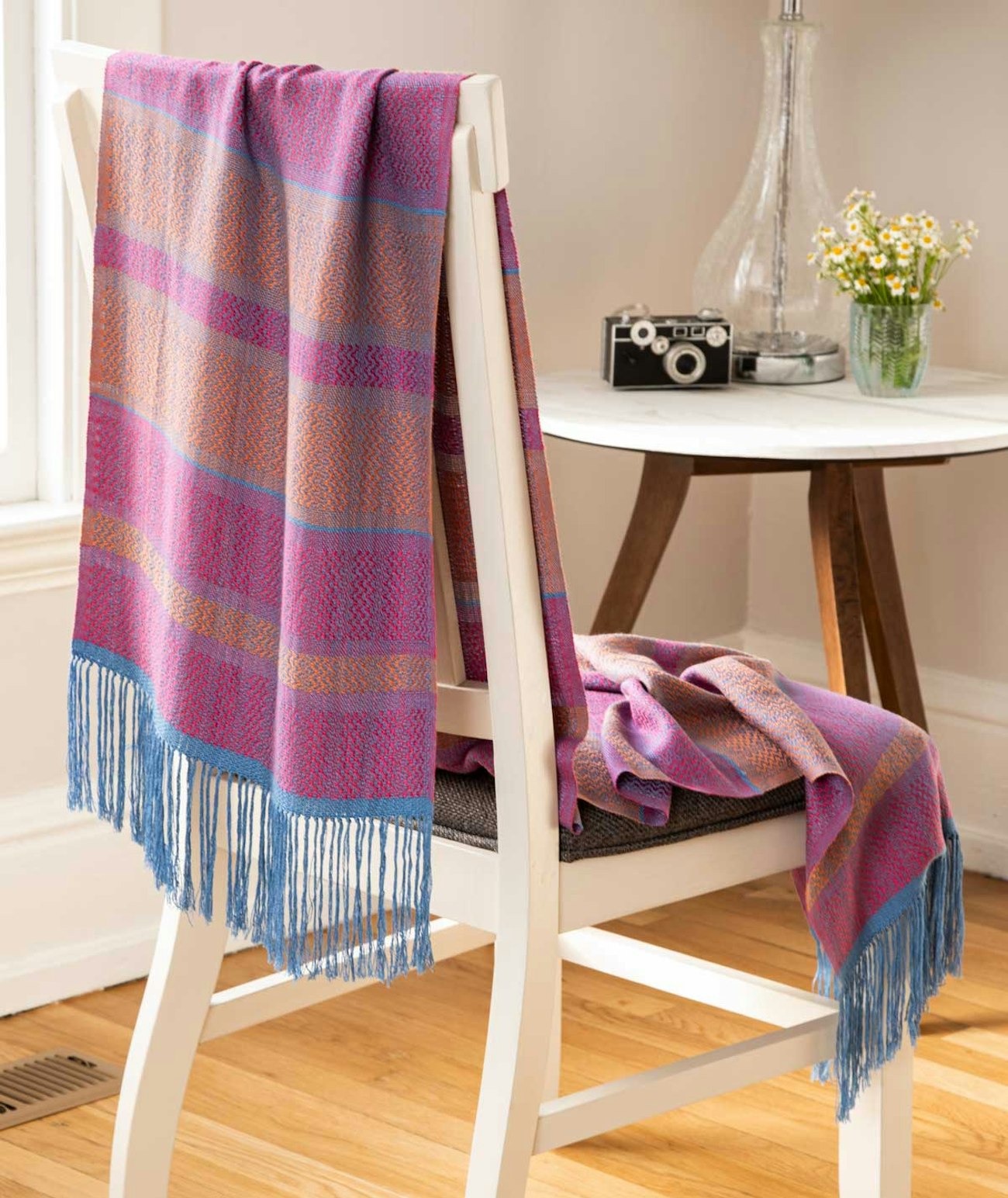 A scarf woven in vivid pink, orange, and blue.