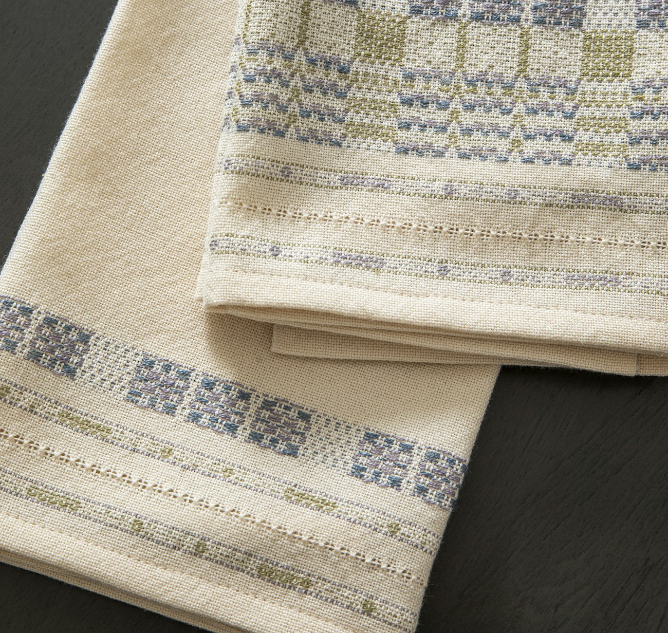 Dishtowels with delicate floral overshot patterning overall and a related border.