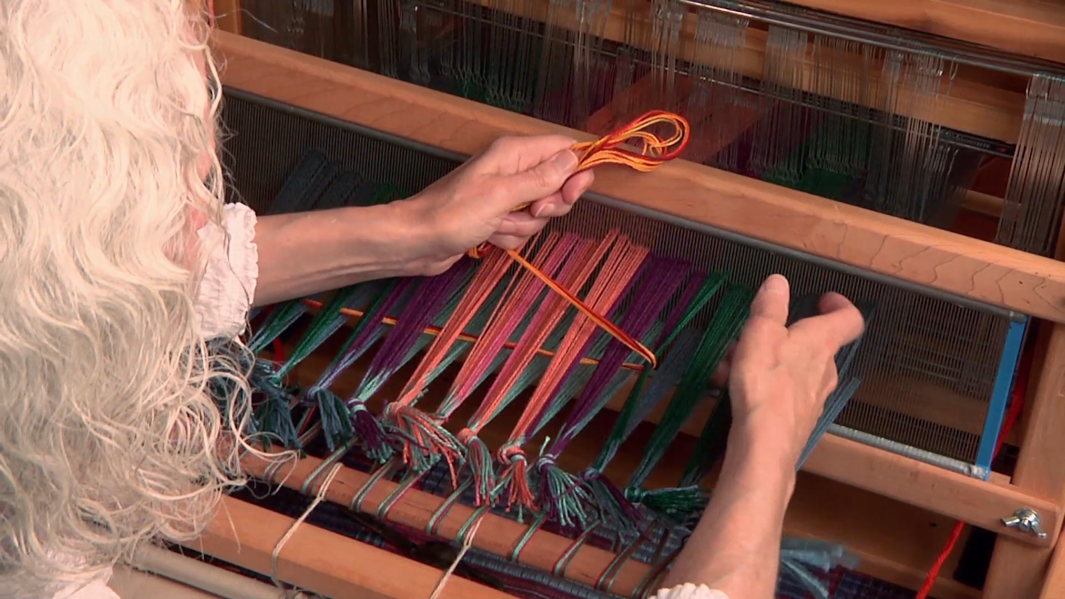 Weaving the first pick of waste yarn through a plain weave shed.