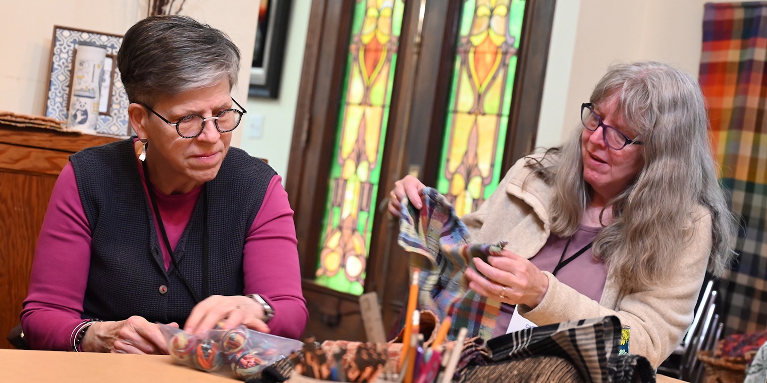 Weavers study sakiori samples during a class at Weave Together 2025.