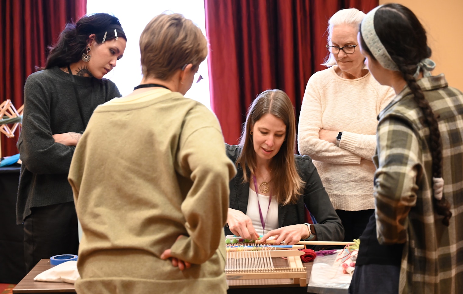 Sara White demonstrates tapestry techniques to students at Weave Together 2026.