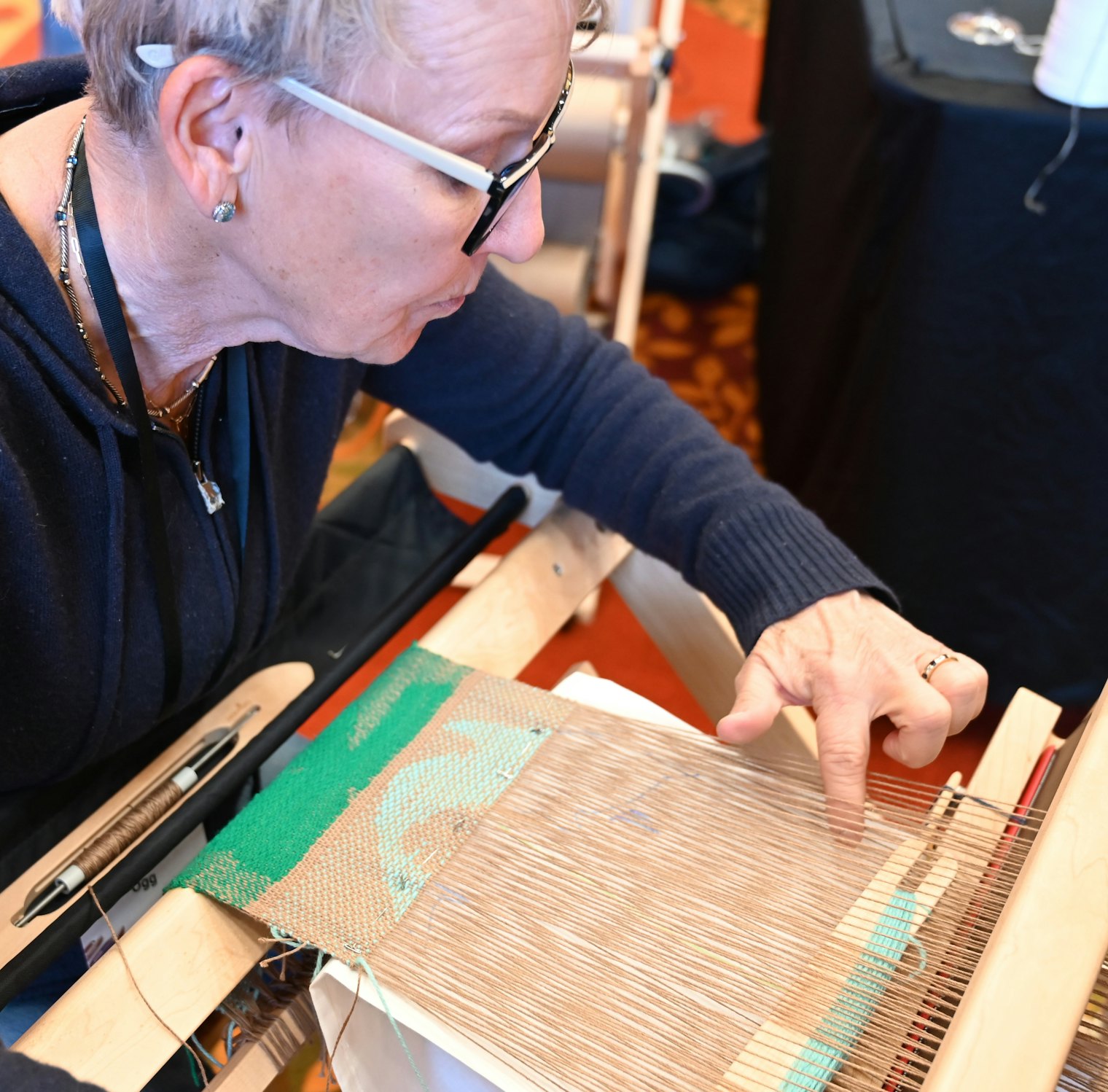Selecting areas for pick-up in the split-shed weaving class at Weave Together 2026.